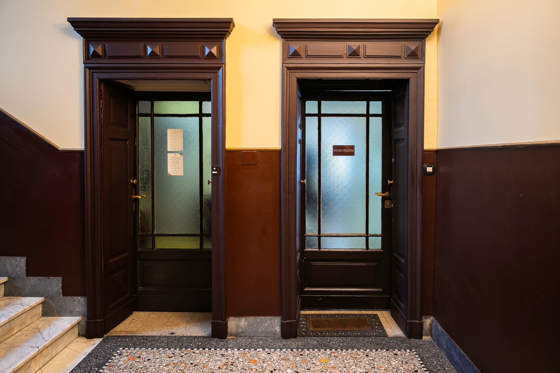 Cinque persone sedute a un tavolo di legno in un ufficio, rivolte in avanti.