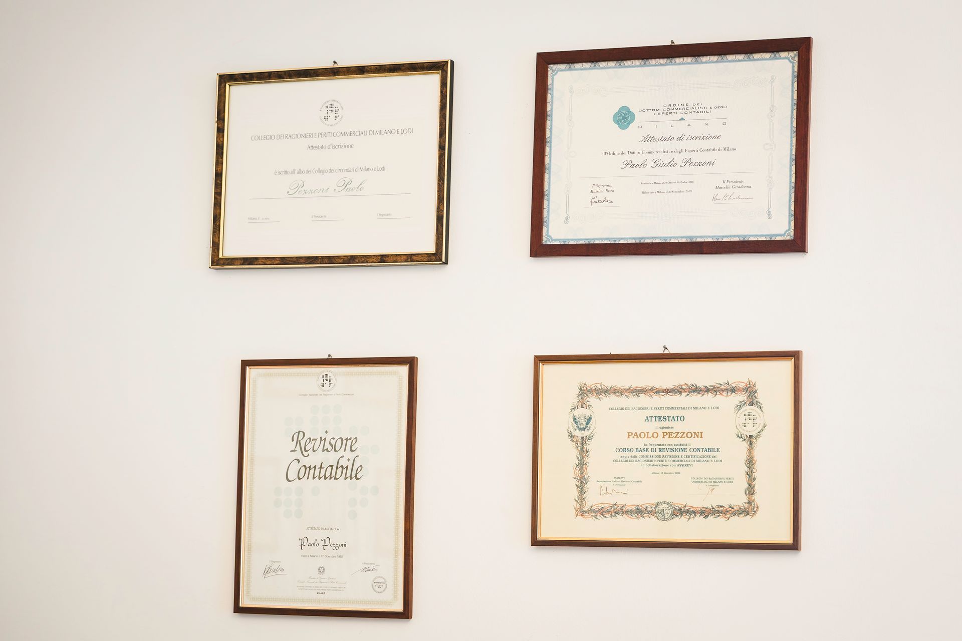 Cinque persone sedute a un tavolo di legno in un ufficio, rivolte in avanti.