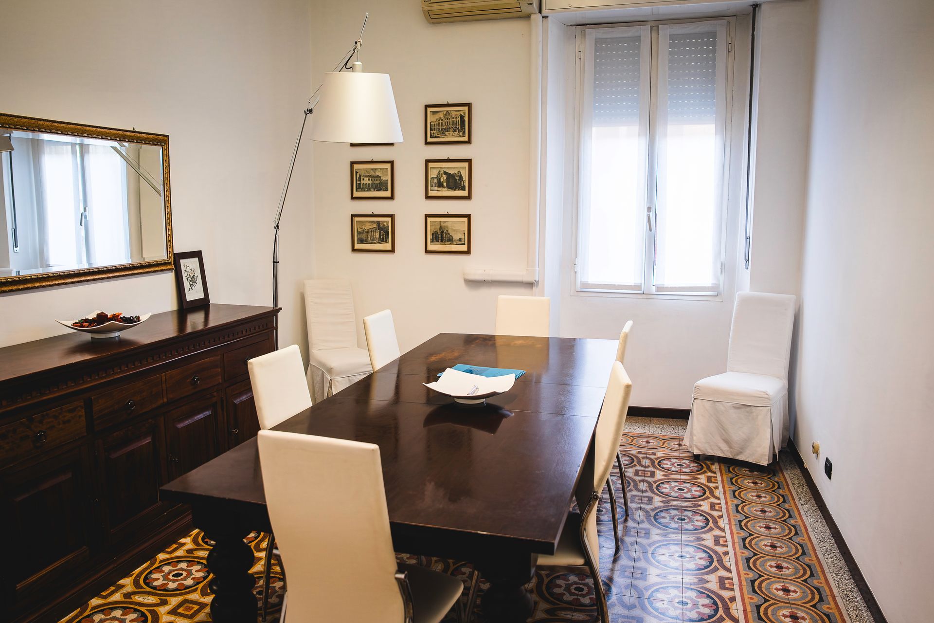 Due persone in abiti da lavoro esaminano dei documenti seduti alla scrivania di un ufficio.