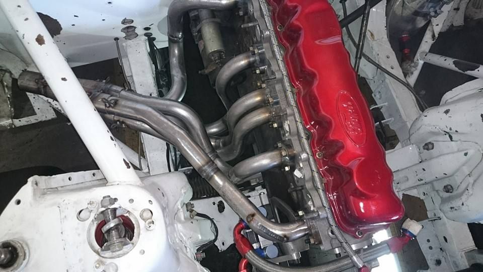 Un primer plano de un motor de automóvil con una cubierta roja.