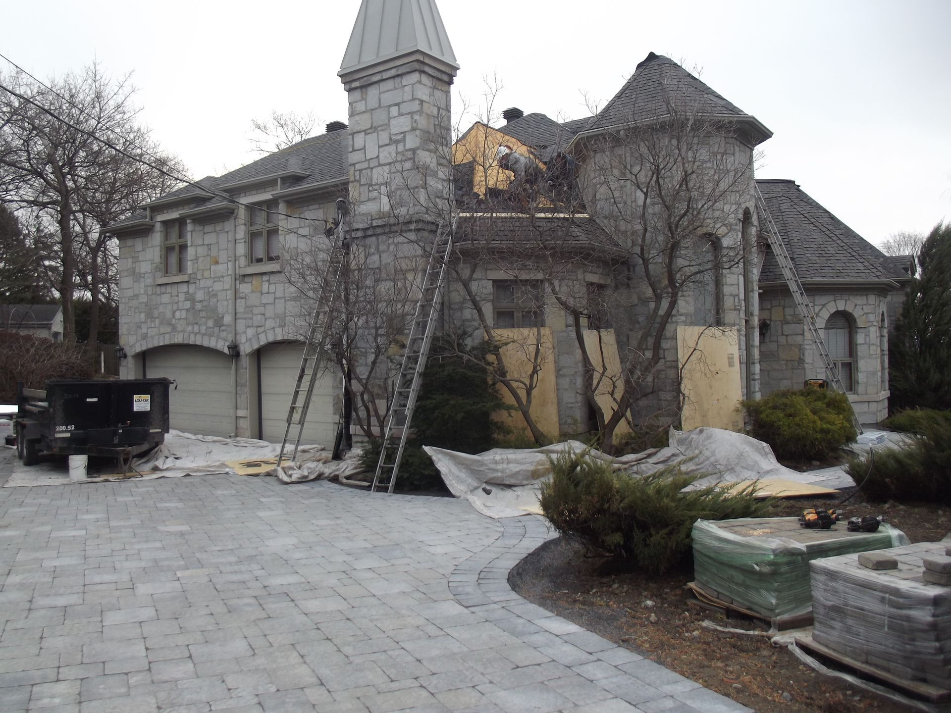 A large stone house with a metal roof is being remodeled