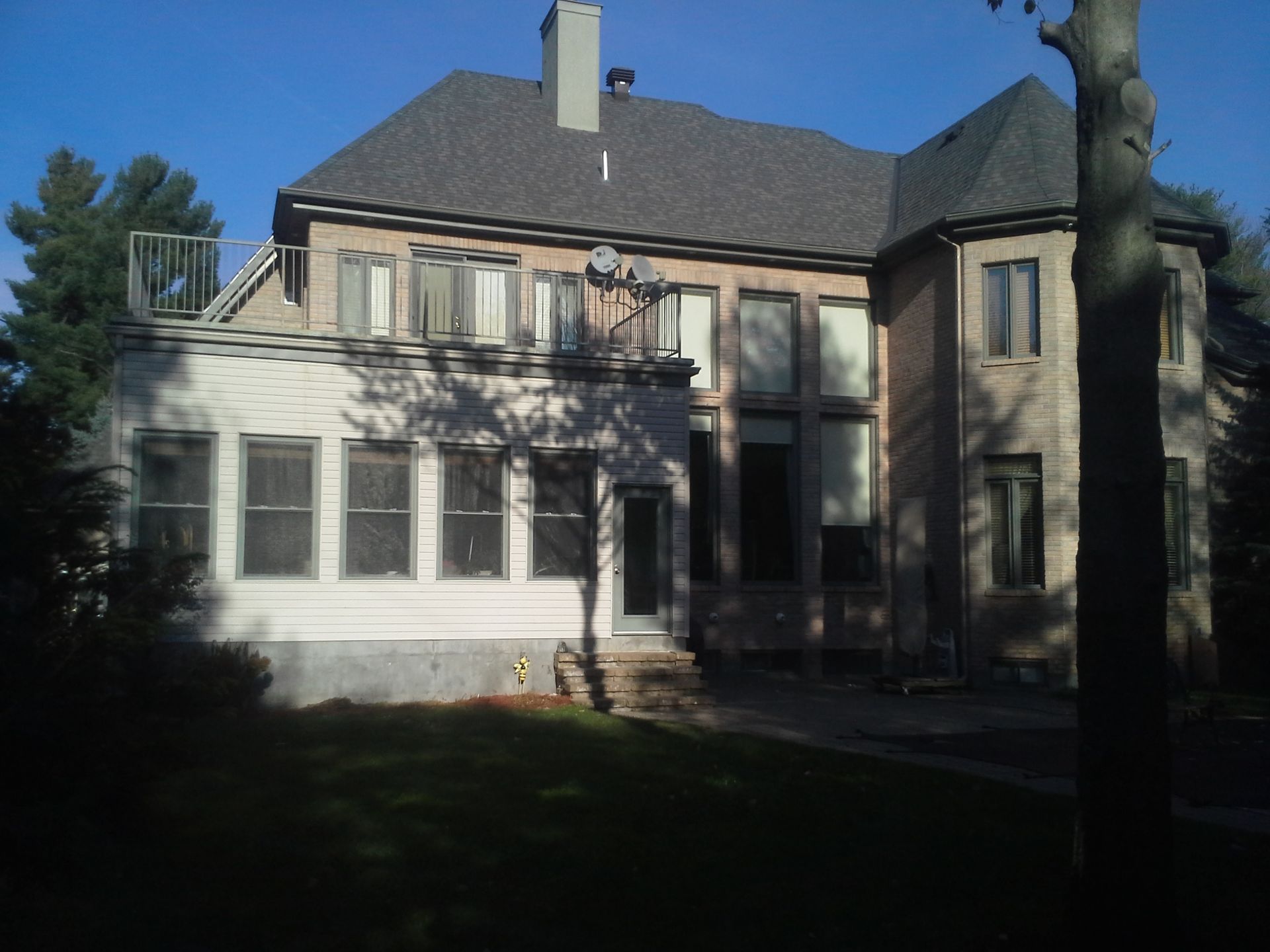 Une grande maison avec un toit gris et beaucoup de fenêtres