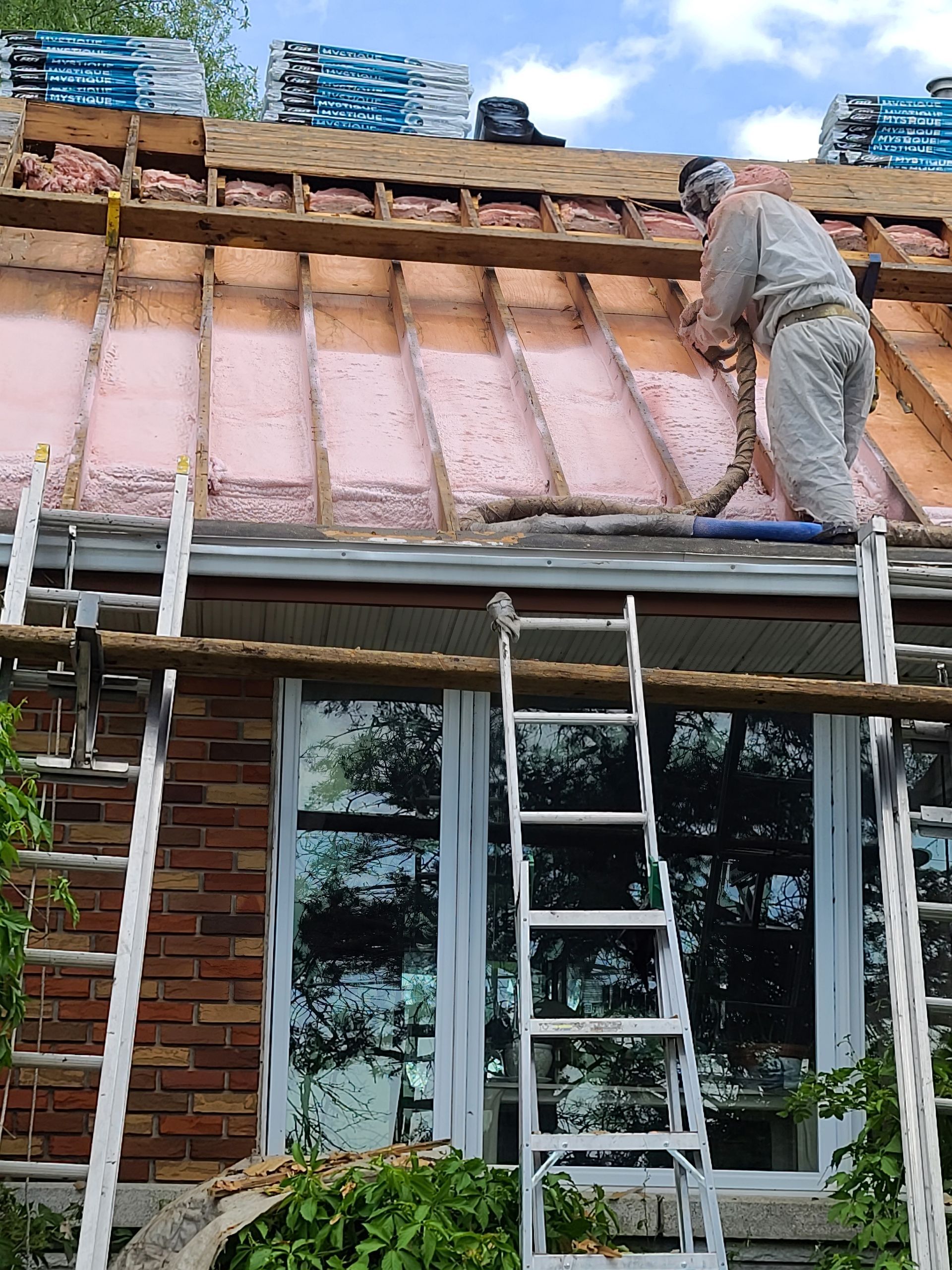 Un homme travaille sur le toit d'une maison