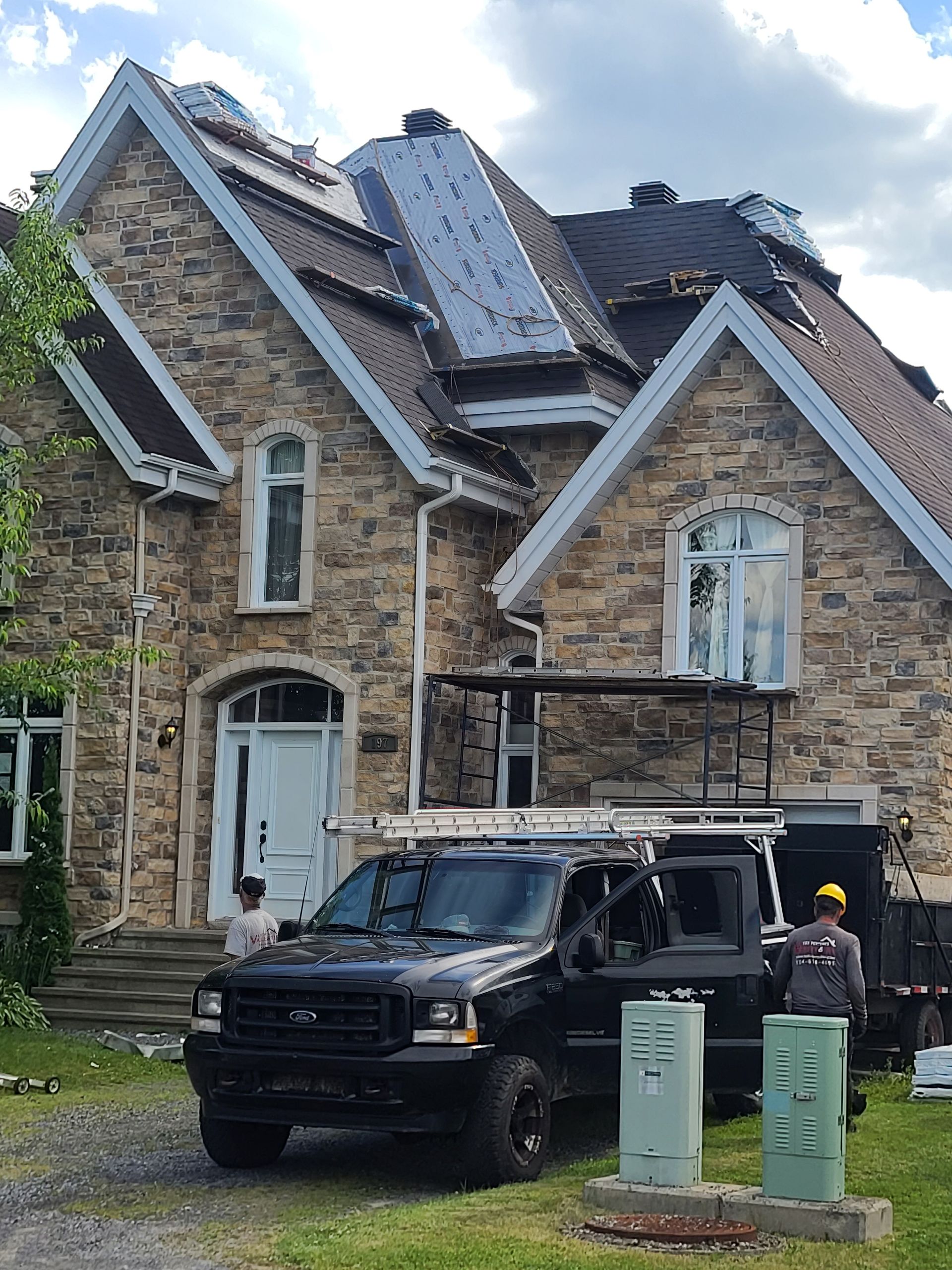 Un camion est garé devant une grande maison en briques.