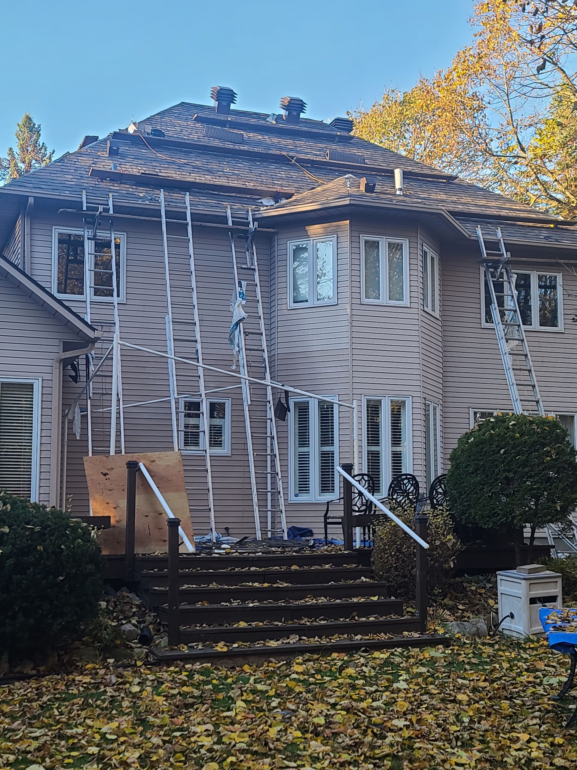 Une grande maison avec un toit en cours de réparation.