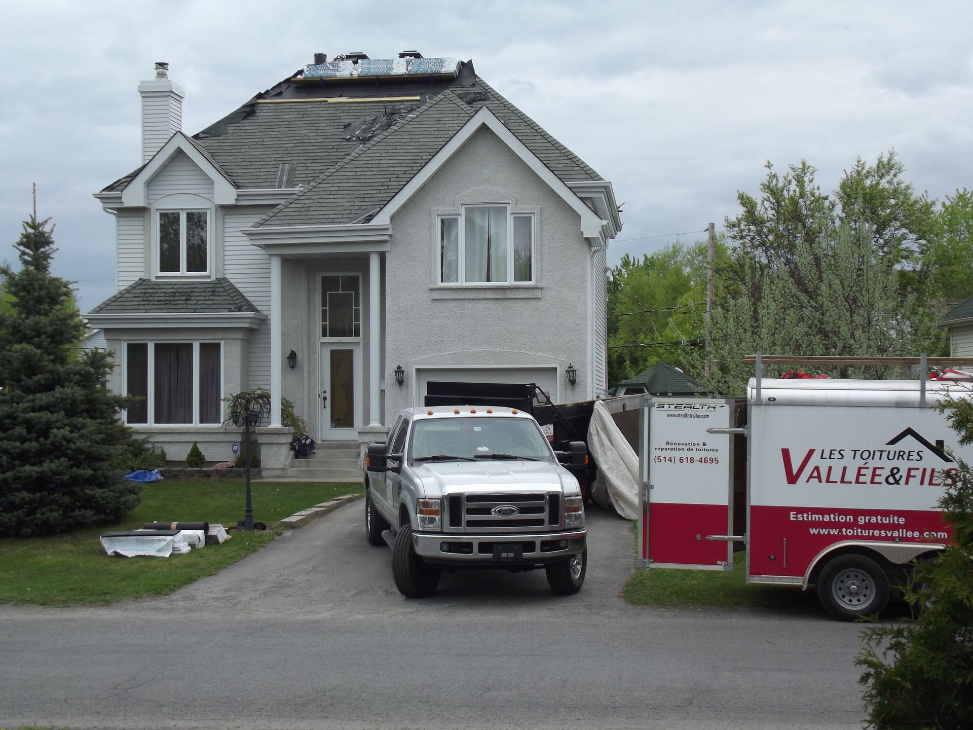 A valley & fils truck is parked in front of a house