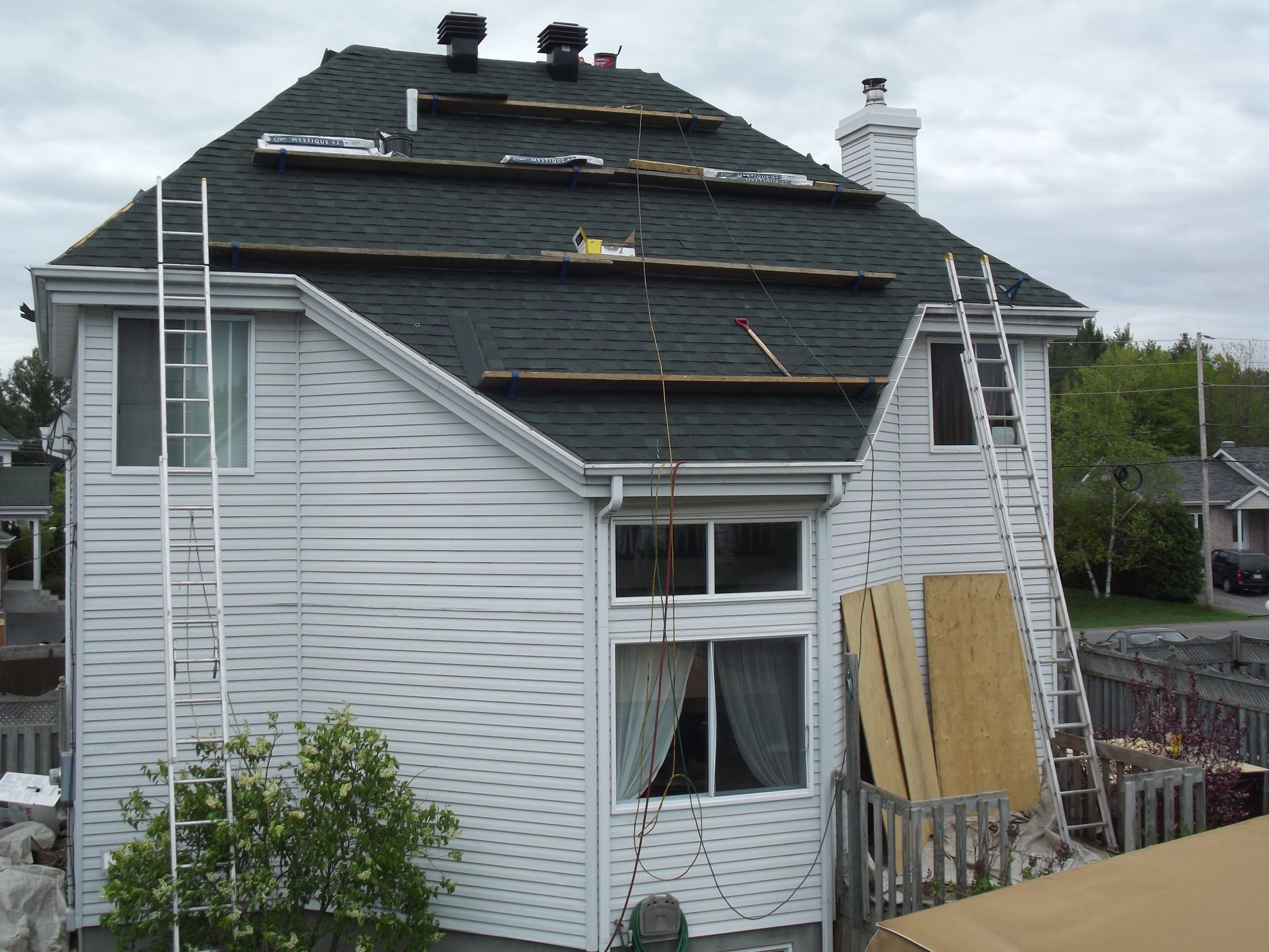 A white house with a black roof under construction