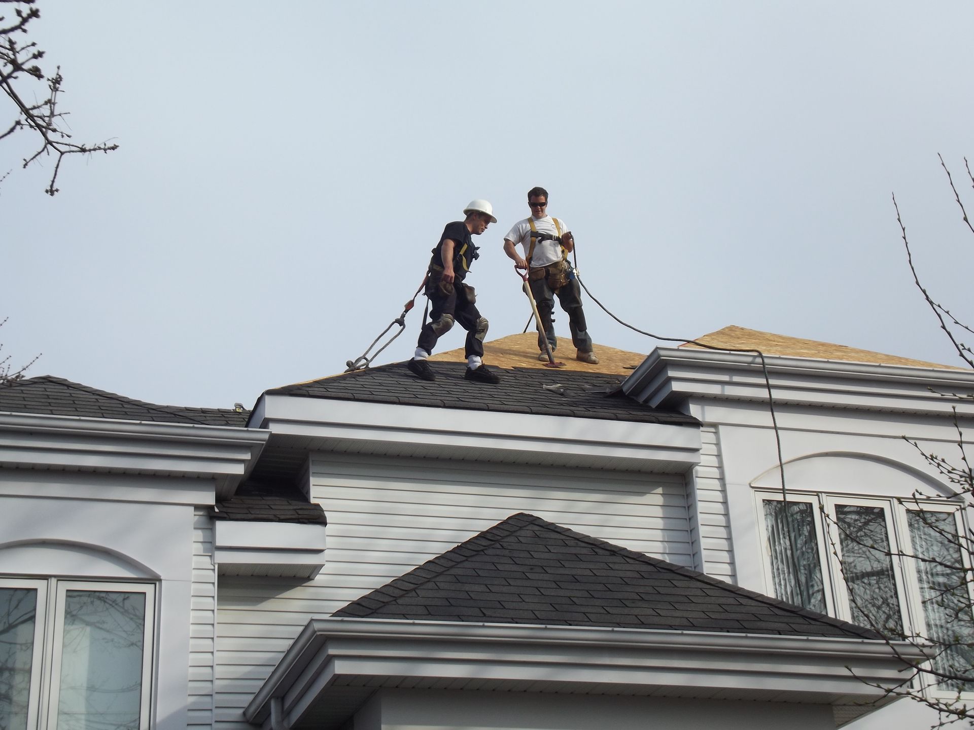 Two men are working on the roof of a house.