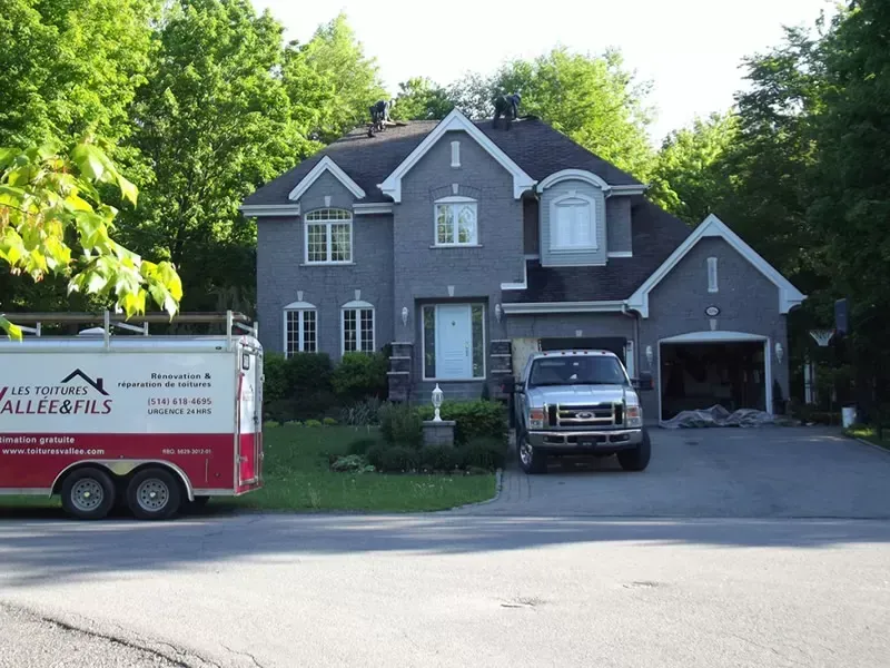 A ford truck is parked in front of a large house