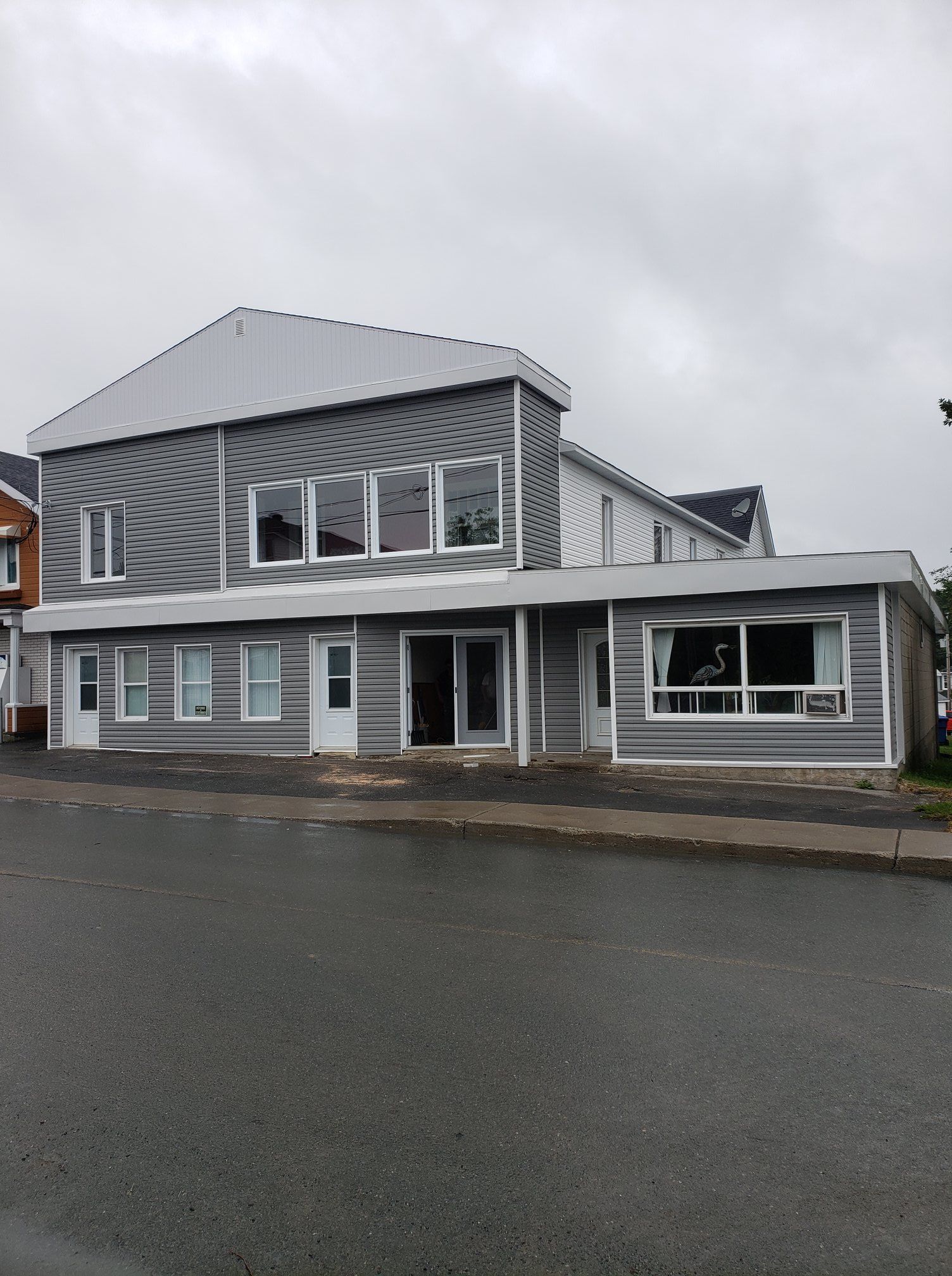 Un grand bâtiment avec beaucoup de fenêtres se trouve sur le côté de la route.