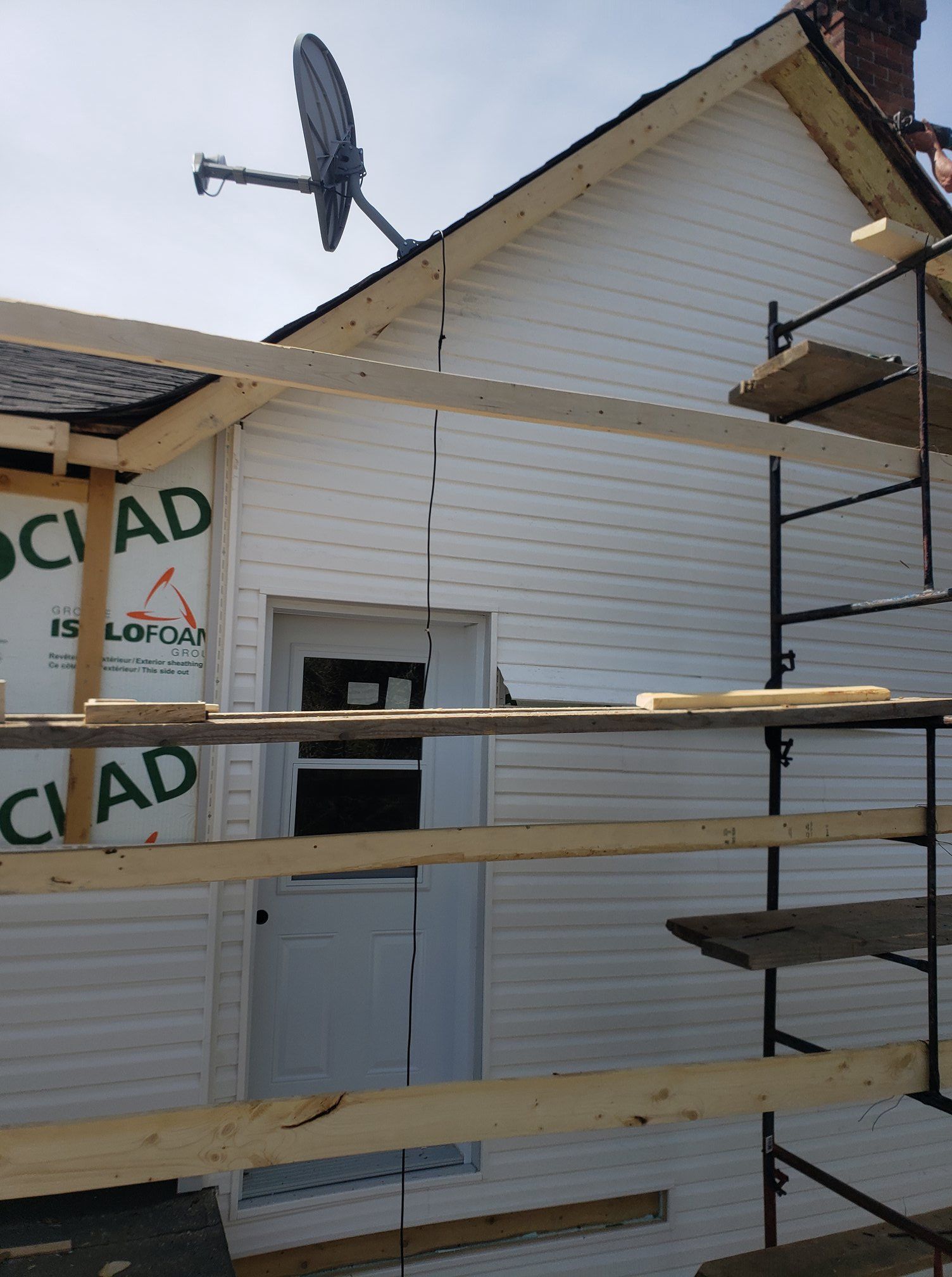 Une antenne parabolique est suspendue au toit d'une maison en construction