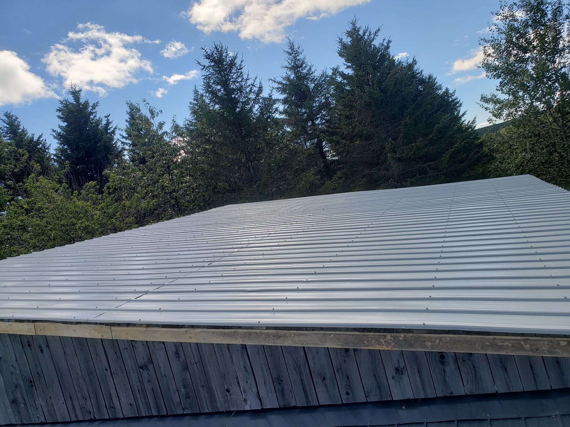 Un toit avec un ciel bleu et des arbres en arrière-plan