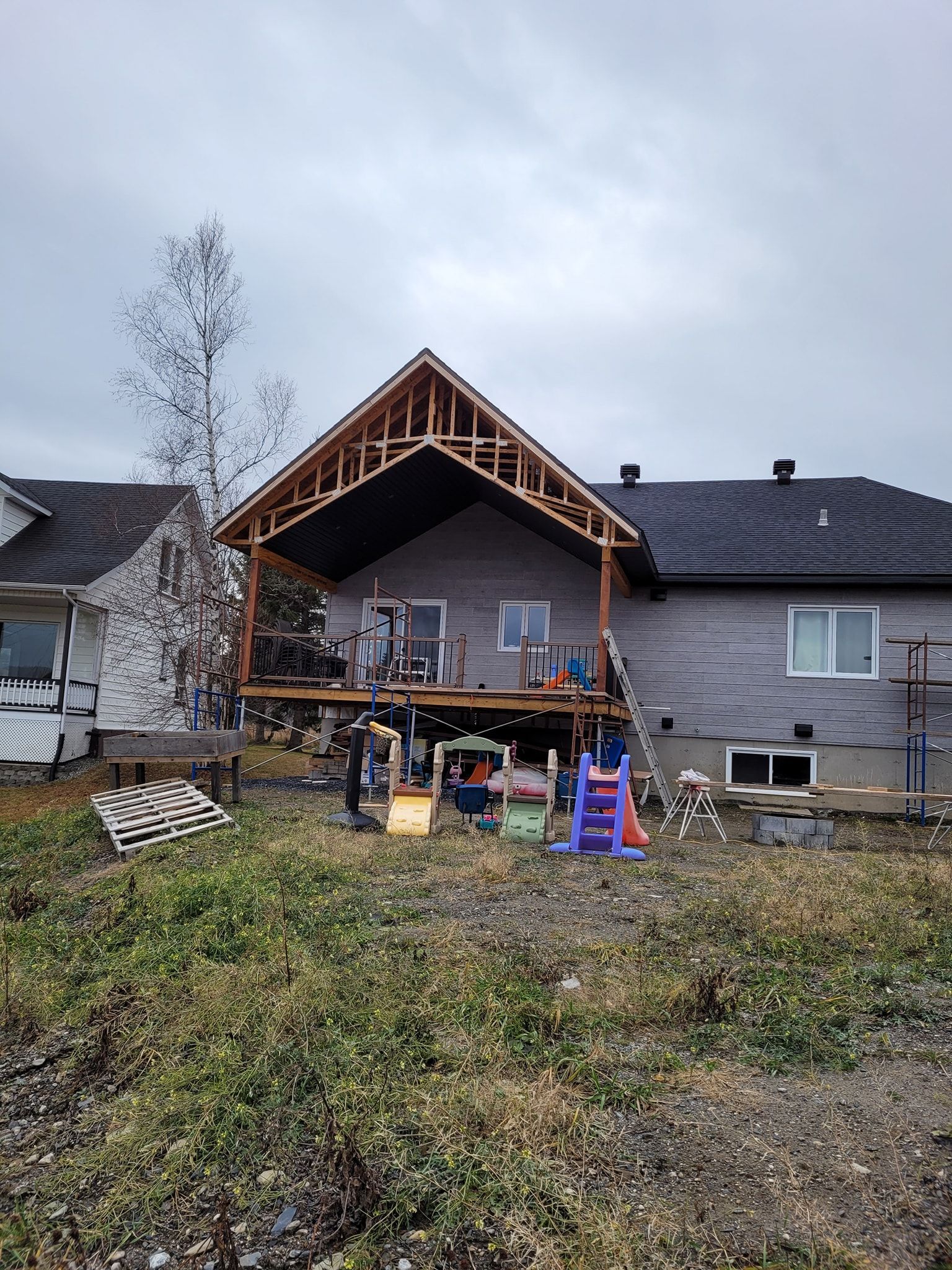 Une maison est en construction avec une terrasse et un toit.
