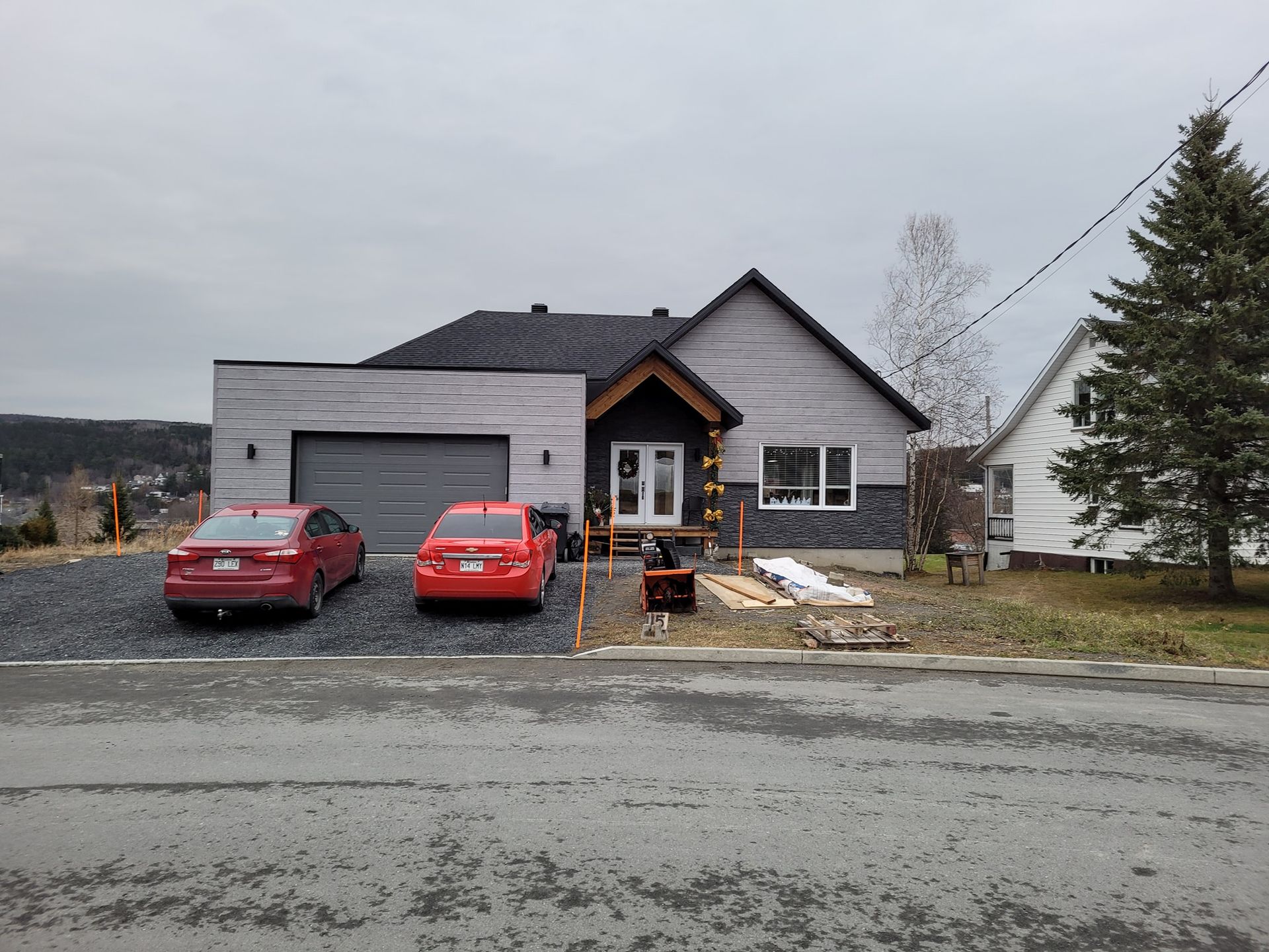 Deux voitures rouges sont garées devant une maison.