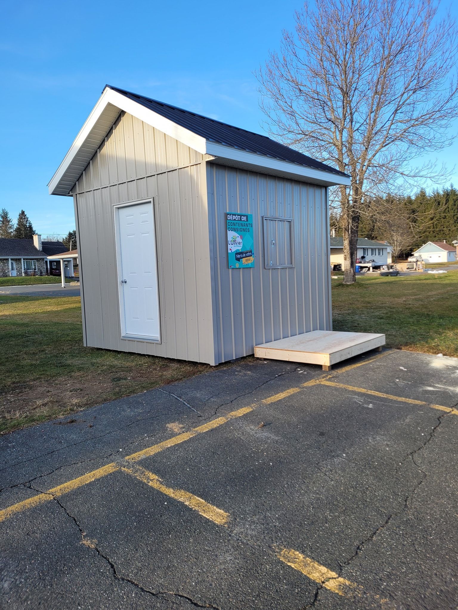Un petit hangar se trouve au milieu d'un parking.