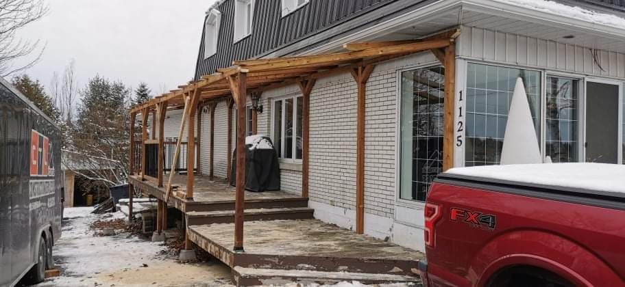 Un camion rouge est garé devant une maison en construction.