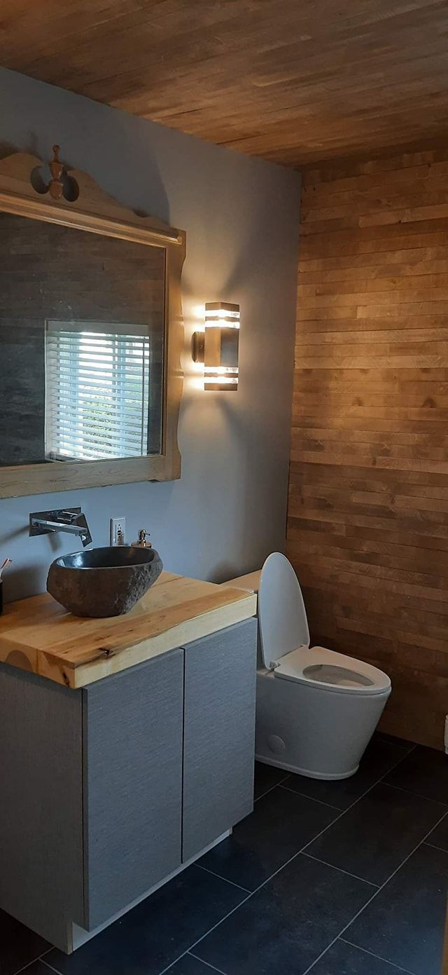 Une salle de bain avec lavabo, WC et miroir.