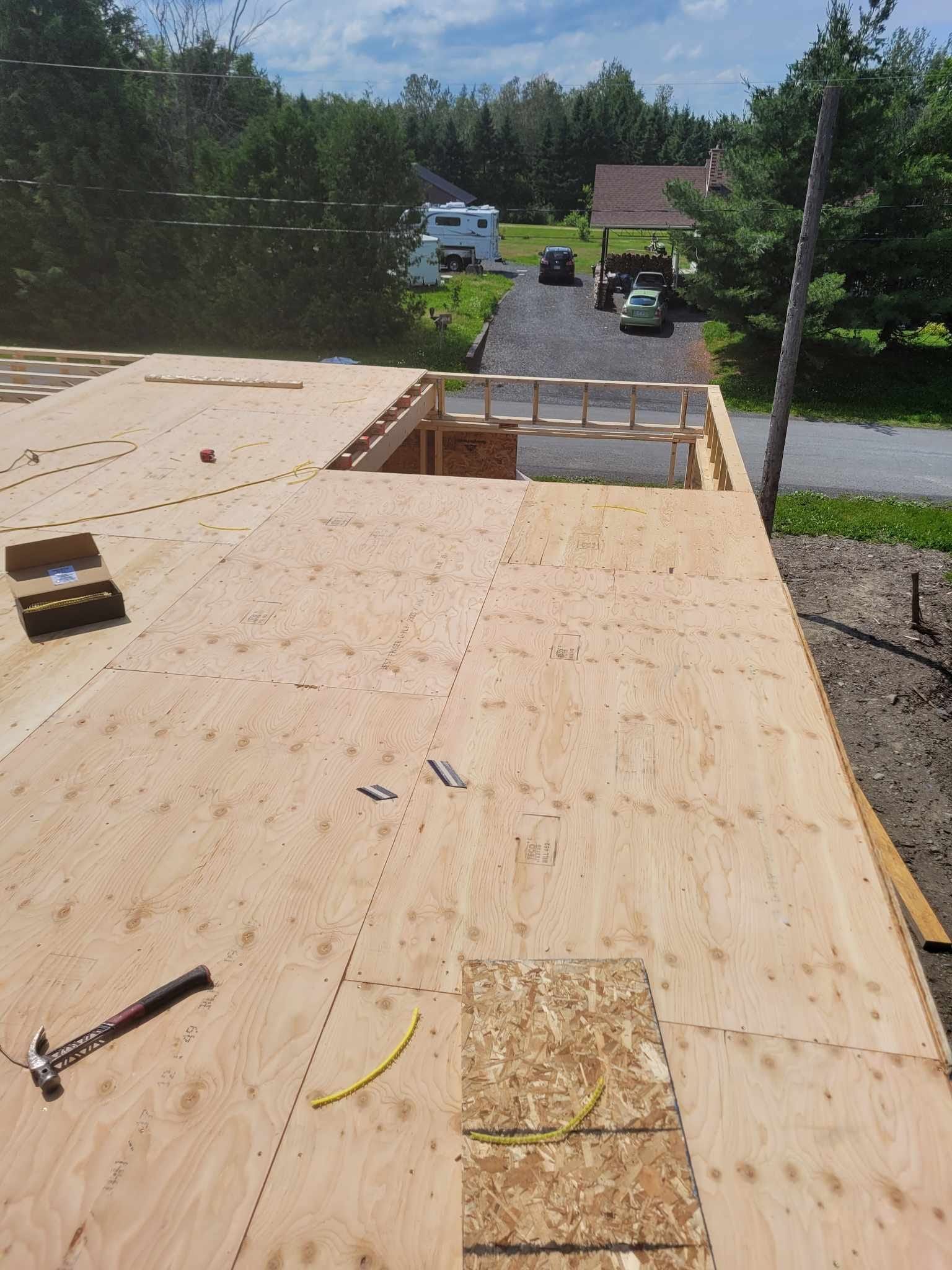 Un toit en bois avec un marteau et un ruban à mesurer dessus