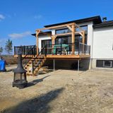 Une maison blanche avec une terrasse en bois et des escaliers