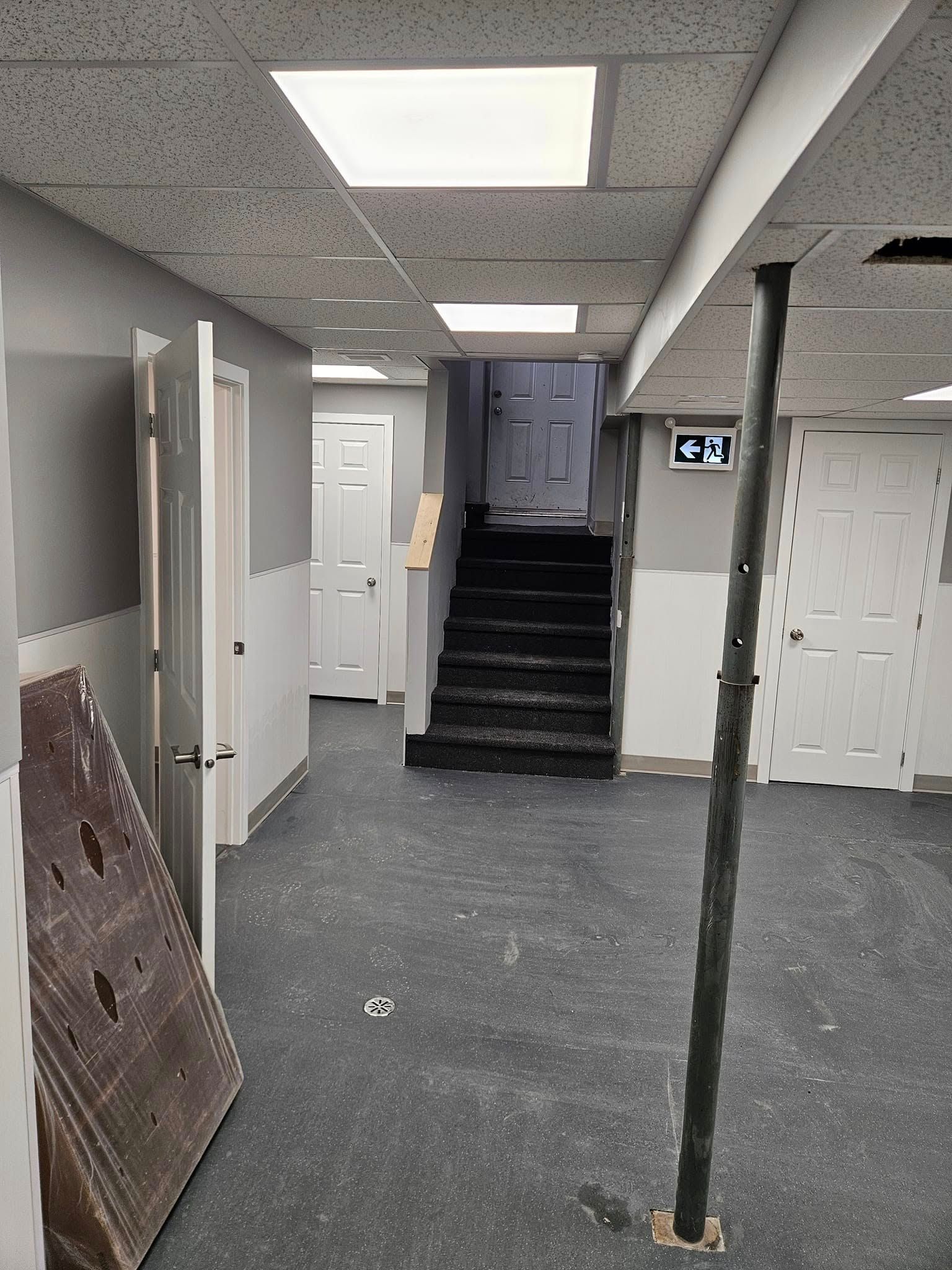 Un sous-sol vide avec des escaliers menant au deuxième étage.