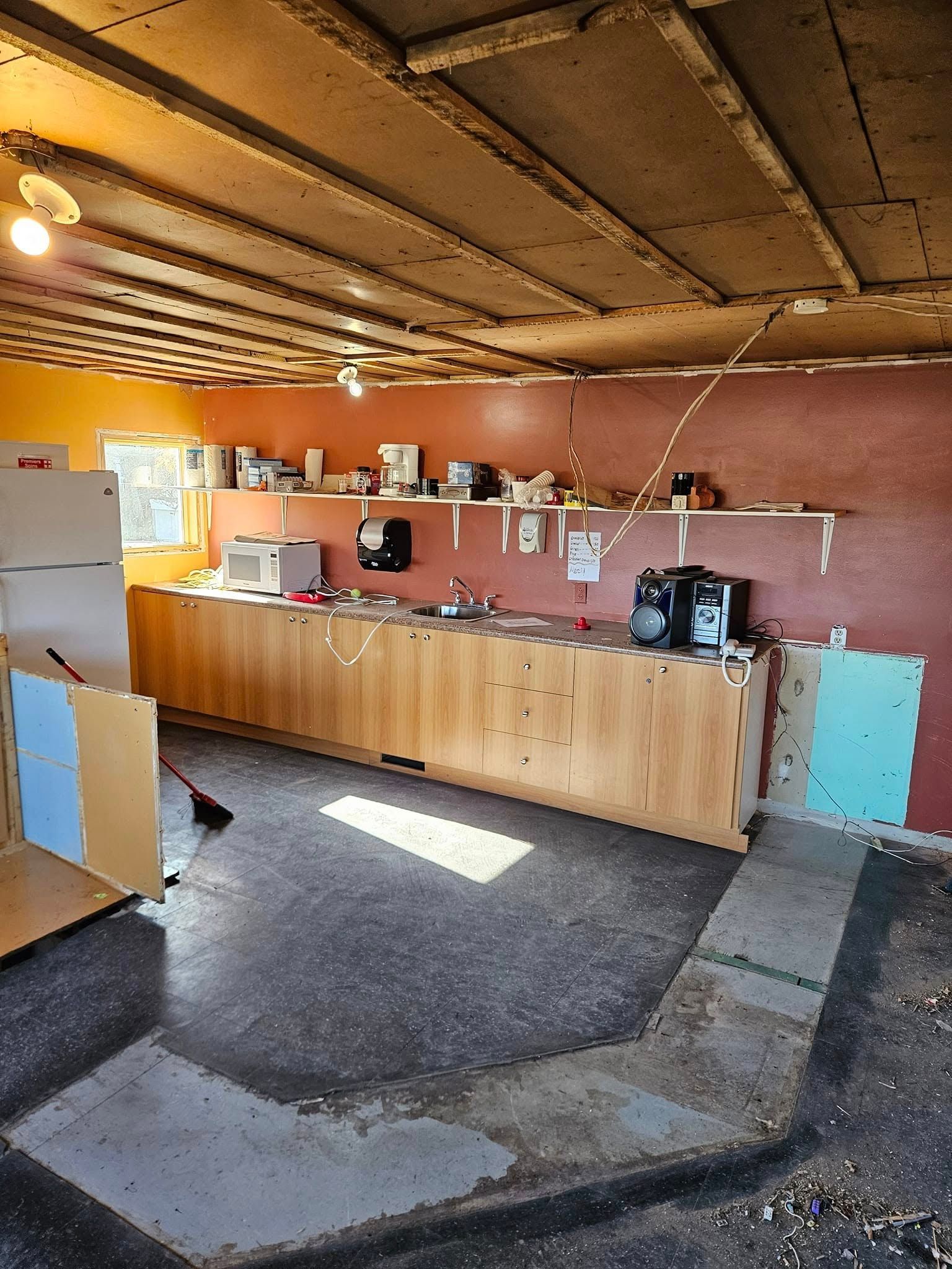 Une cuisine avec un réfrigérateur, un évier et un micro-ondes.