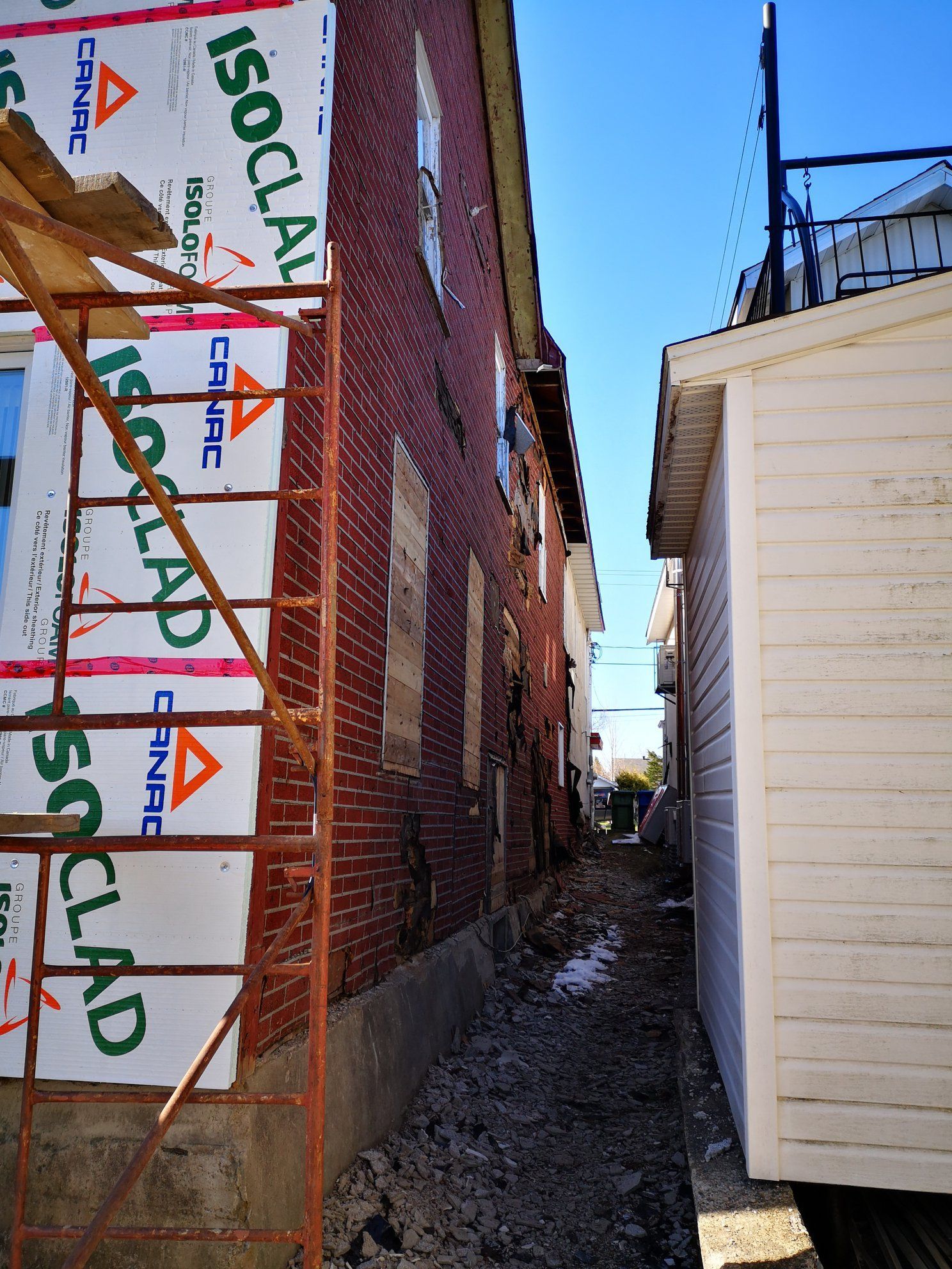 Un bâtiment en brique est en cours de rénovation avec une isolation isoclad
