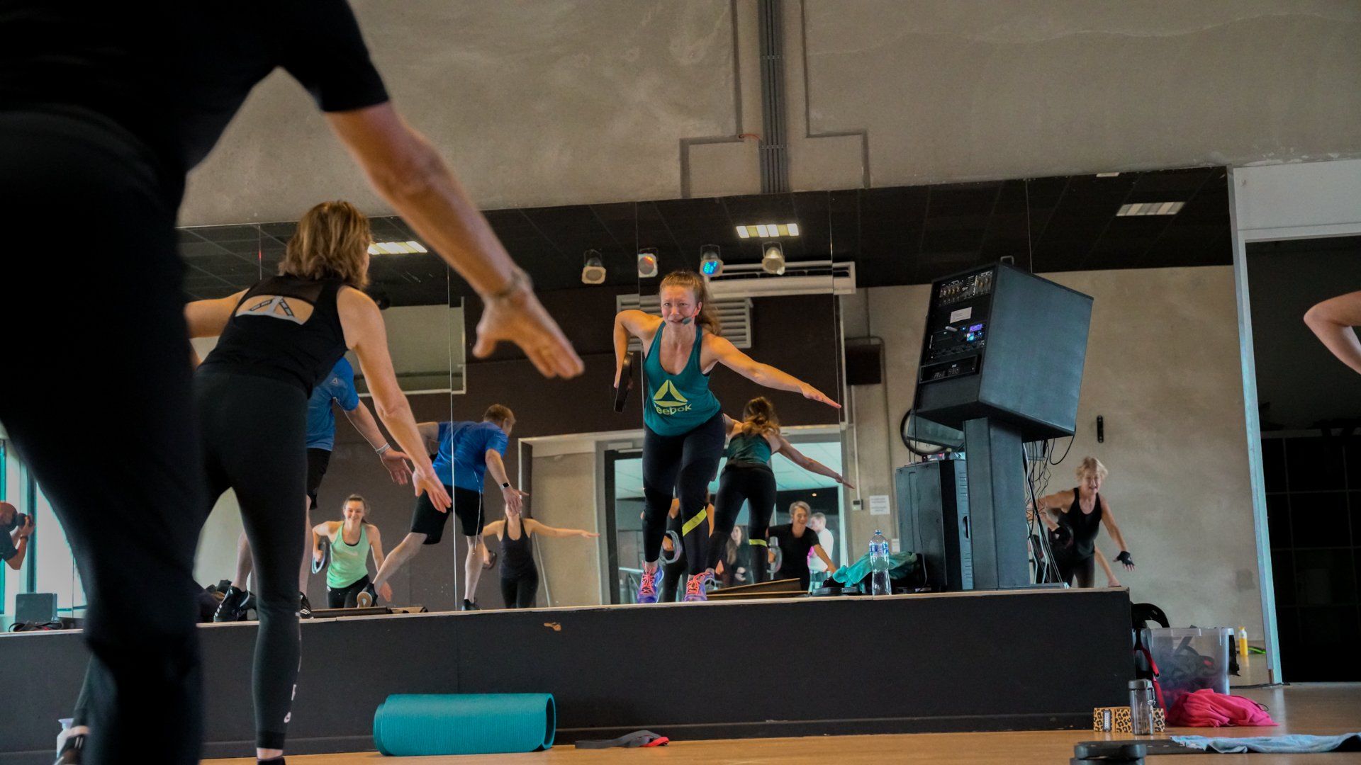 Een groep mensen doet sportoefeningen in een sportschool.