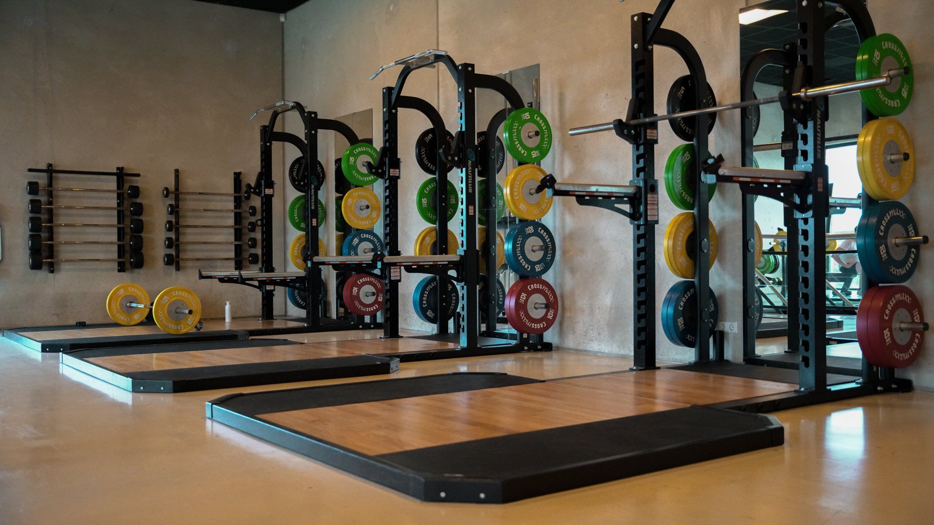 Een sportschool vol met allerlei fitnessapparatuur en gewichten.