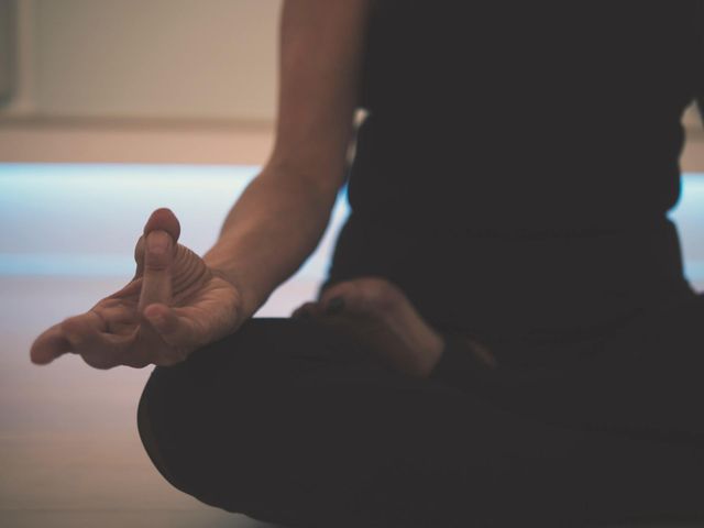 een vrouw zit in een lotushouding met haar handen in een meditatiehouding.
