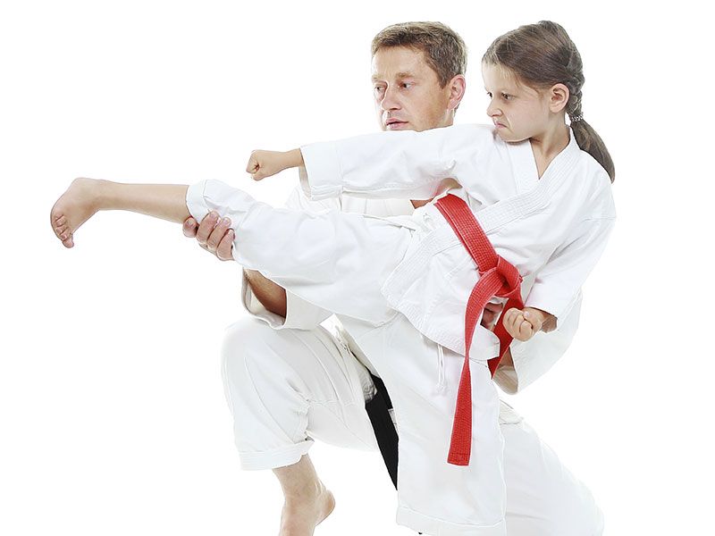 A man and a little girl are practicing karate together.