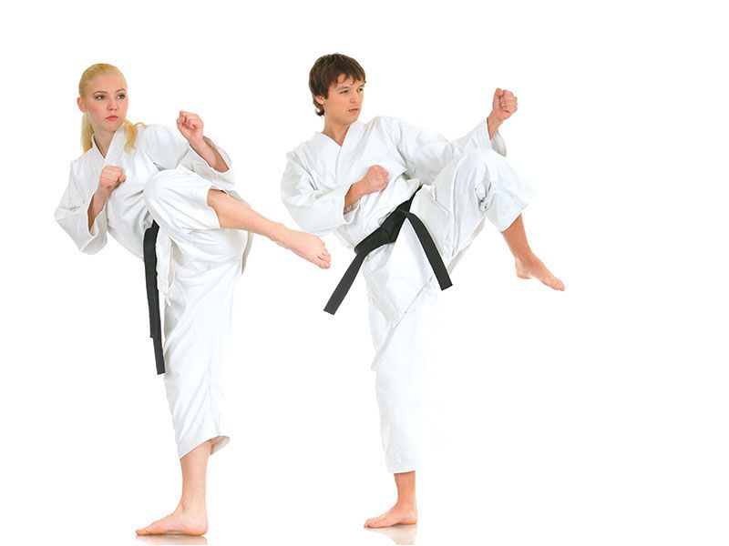 A boy and a girl are practicing karate on a white background.