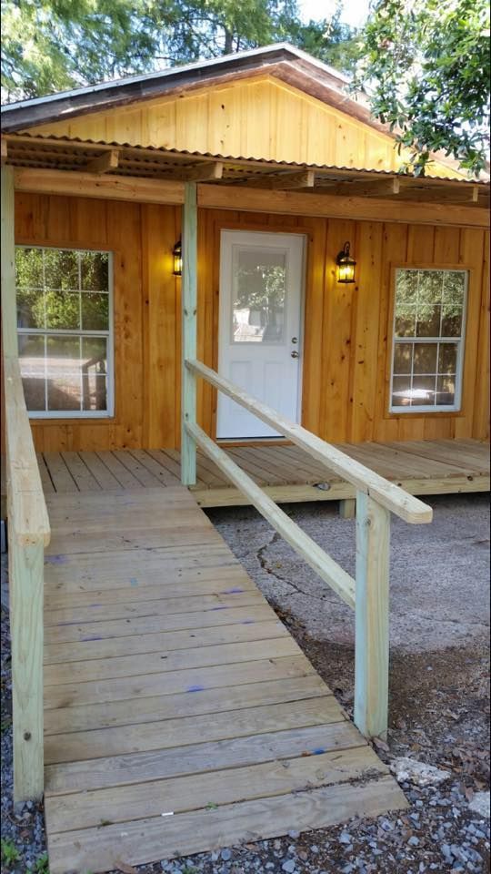 A wooden house with a ramp leading to the door