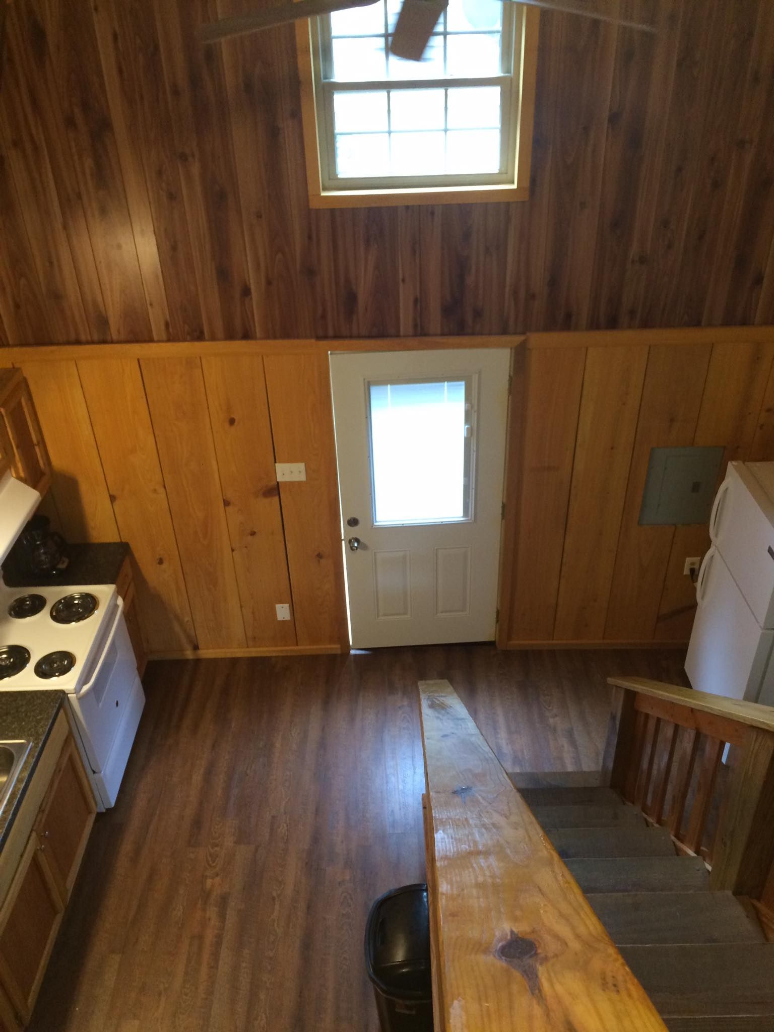 An aerial view of a kitchen with wood paneling and stairs