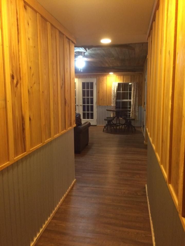A hallway in a house with wood paneling and a picnic table