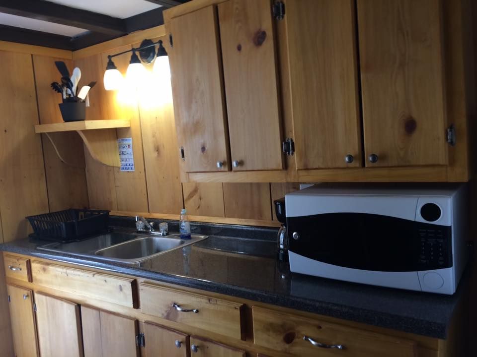 A kitchen with wooden cabinets a sink and a microwave