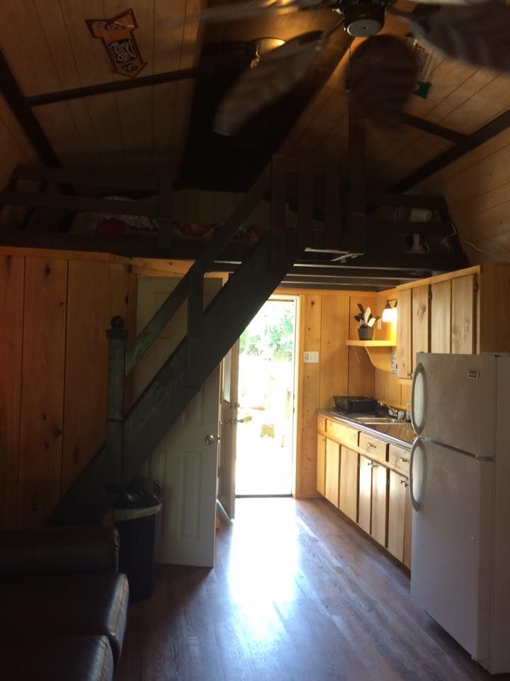 A kitchen with a refrigerator and stairs leading up to the second floor
