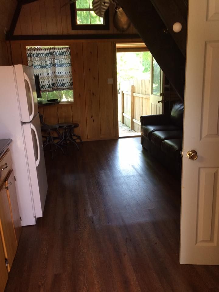 A kitchen with a refrigerator and a couch in it