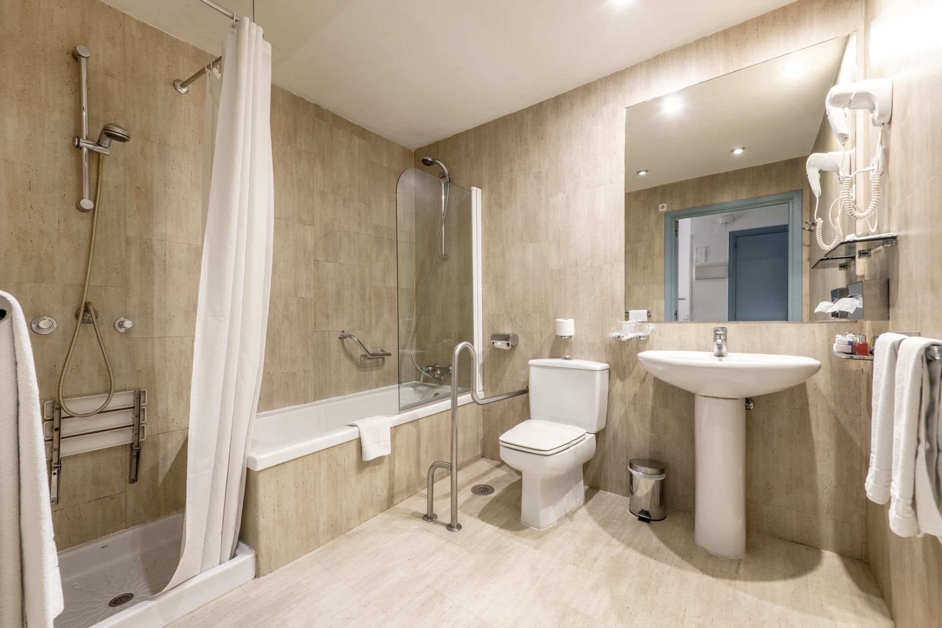 A bathroom with a toilet , sink , bathtub and shower.
