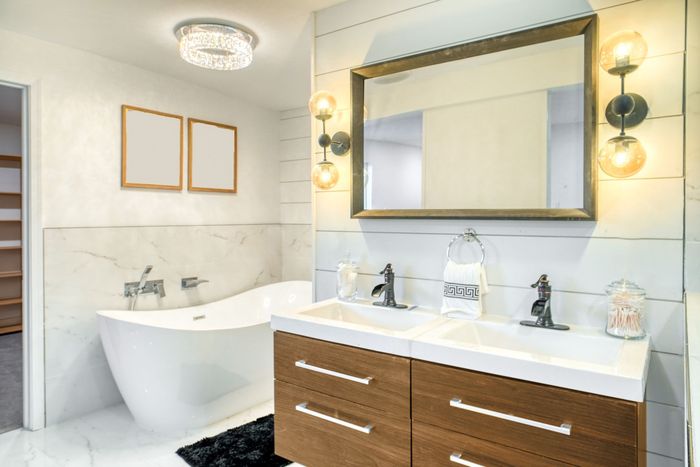 A bathroom with two sinks , a bathtub and a mirror.