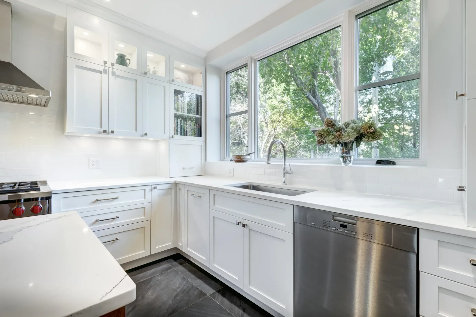 A kitchen with white cabinets and a large island in the middle.