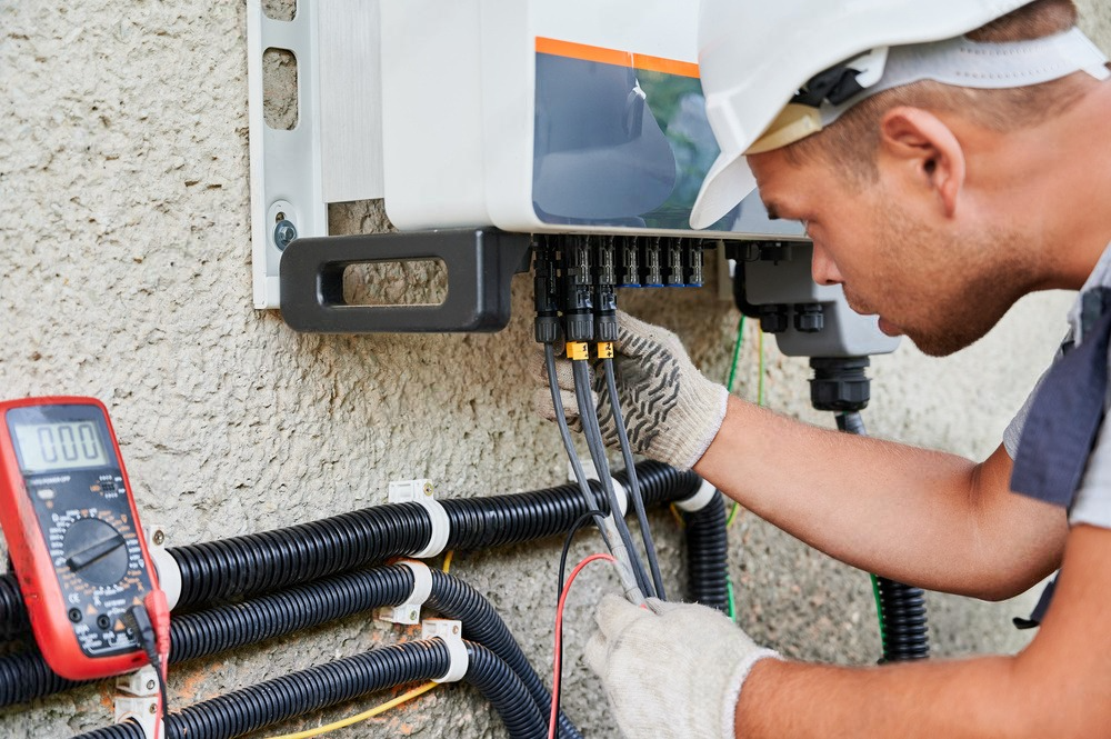 a man is working on a solar panel with a multimeter .