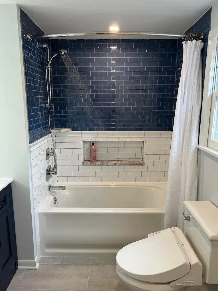 A bathroom with a bathtub , toilet and shower.