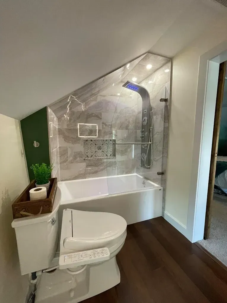 A bathroom with a toilet , bathtub and shower.