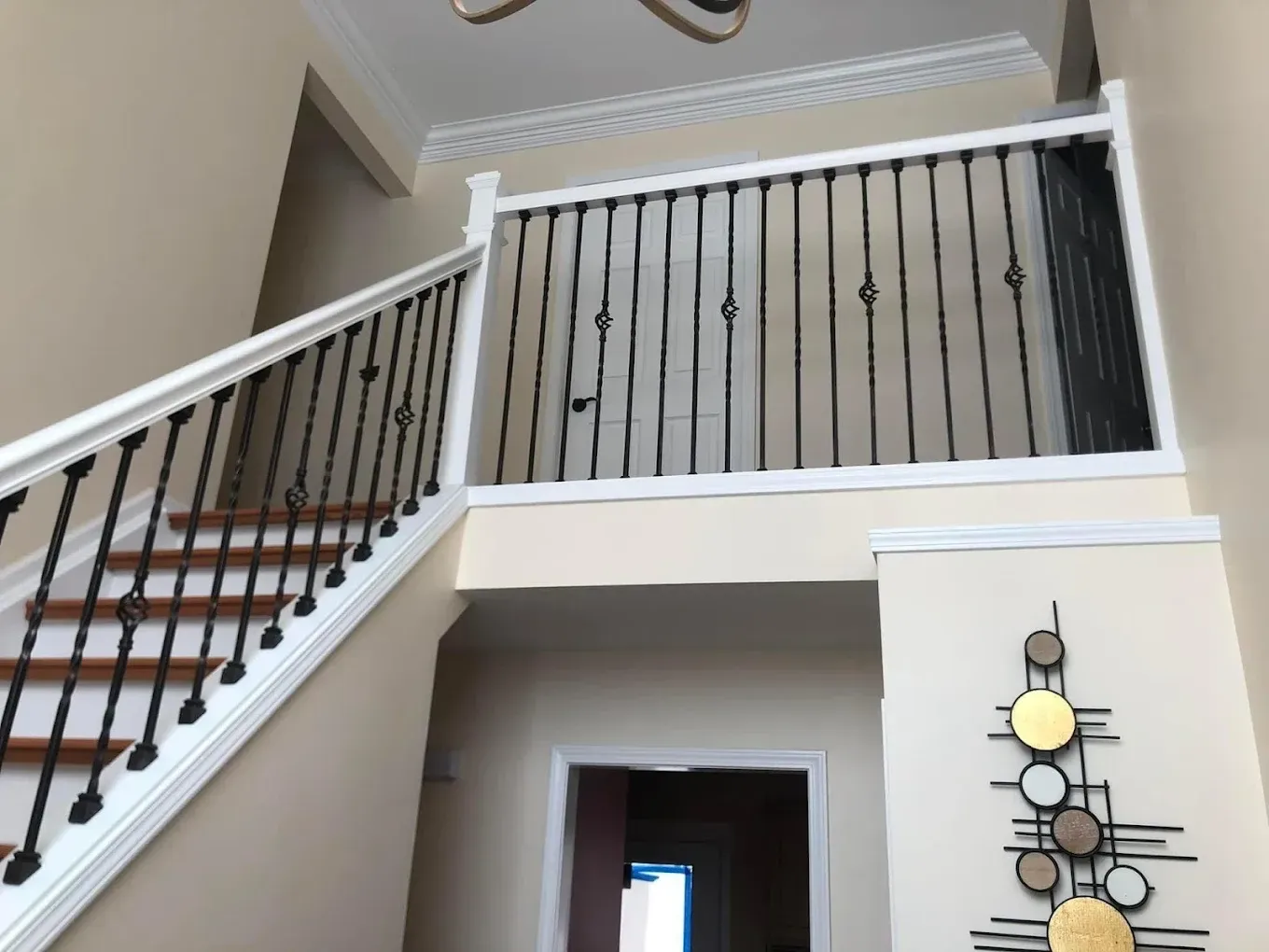 A staircase in a house with a wrought iron railing