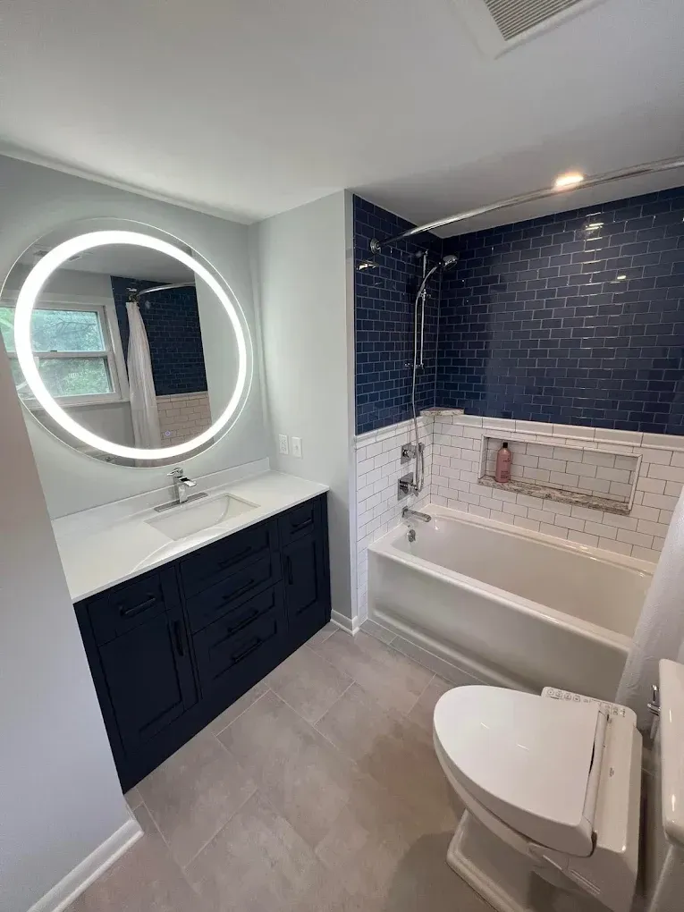 A bathroom with a sink , toilet , tub and mirror.