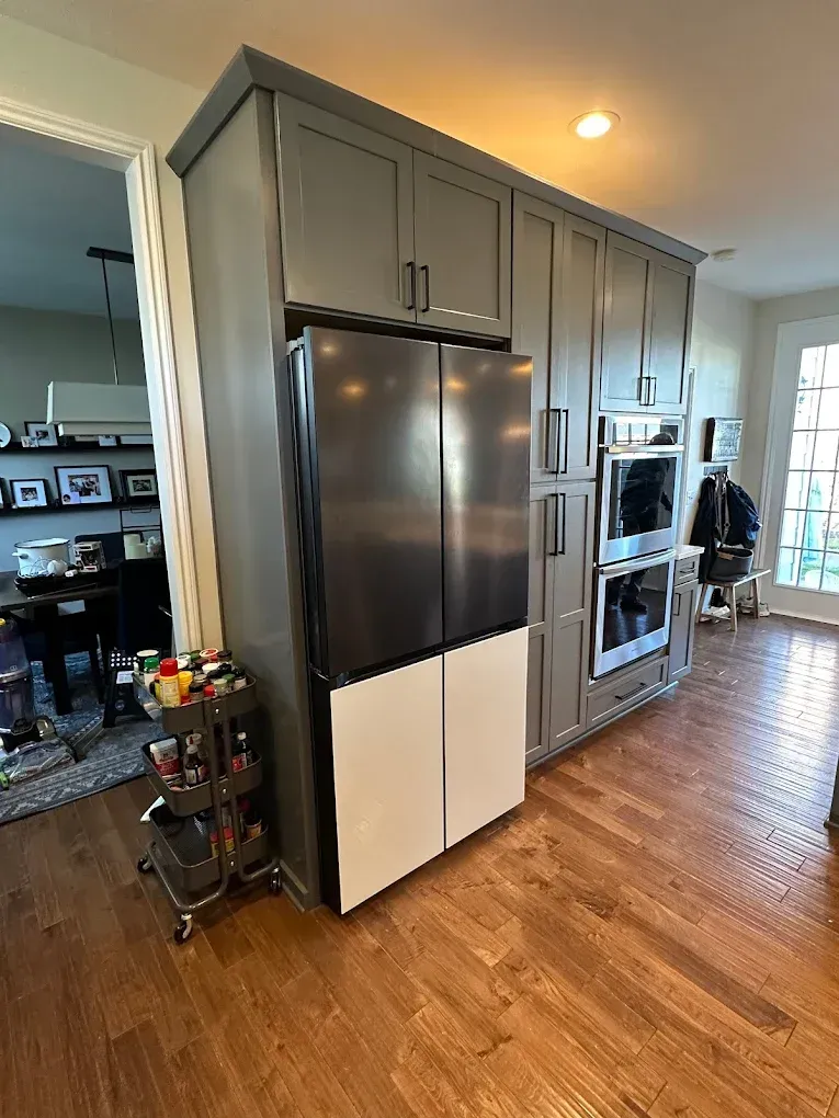 A kitchen with stainless steel appliances and gray cabinets.