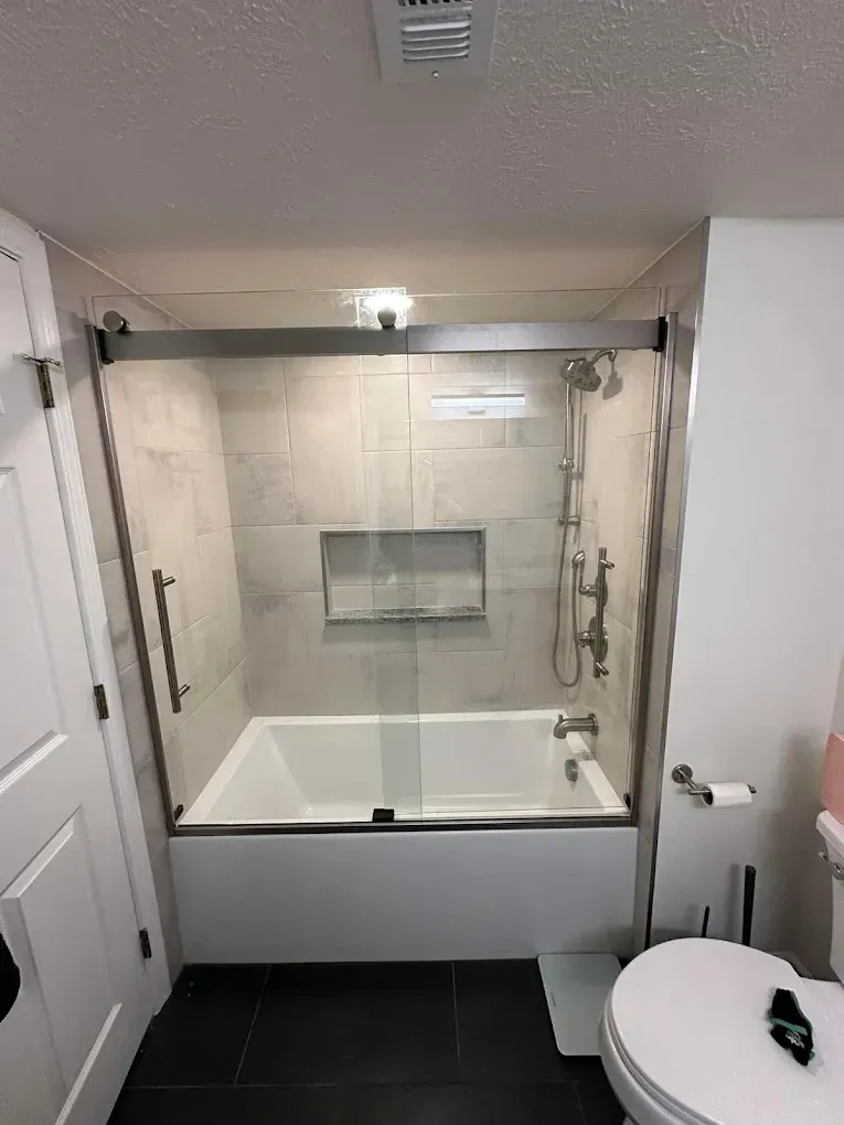 A bathroom with a bathtub , toilet and shower.