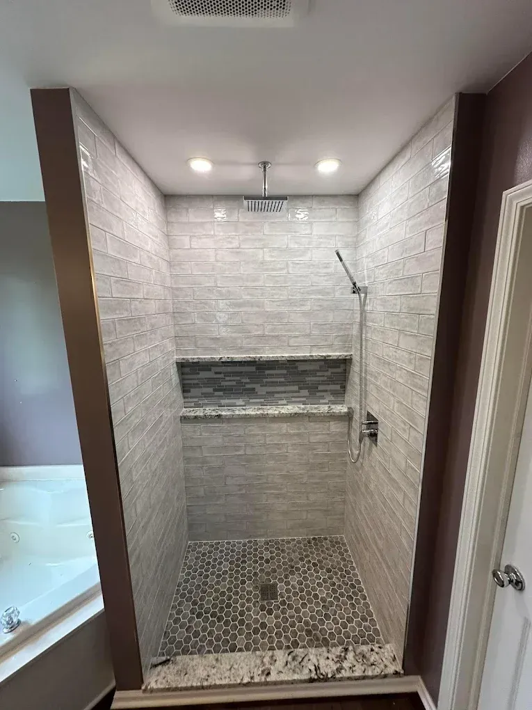 A bathroom with a walk in shower and a bathtub.