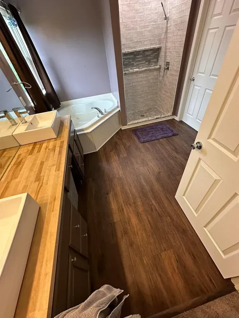 A bathroom with two sinks , a tub , and a walk in shower.