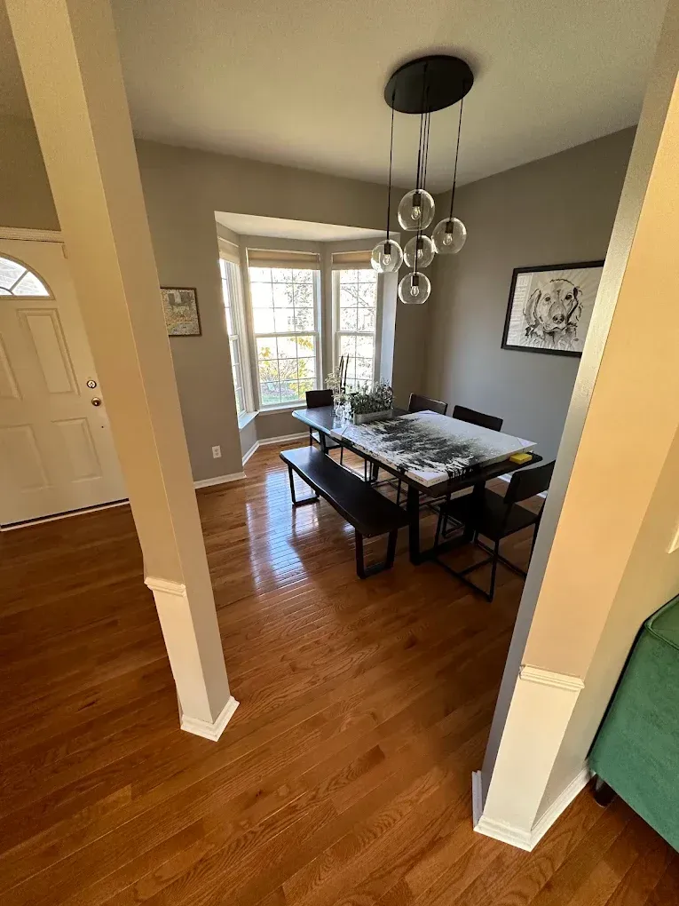 A dining room with a table and chairs and a bench.